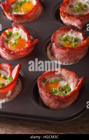 Uova calde avvolto in pancetta vicino fino in una teglia sul piano verticale. Foto Stock