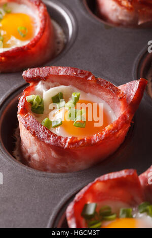 Uova al forno avvolto in pancetta croccante macro nella teglia da forno verticale. Foto Stock