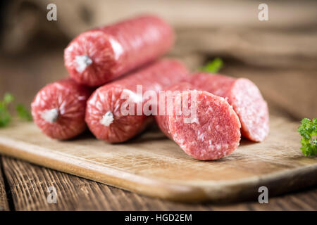 Mettwurst (cucina tedesca; messa a fuoco selettiva) sull'annata sullo sfondo di legno Foto Stock