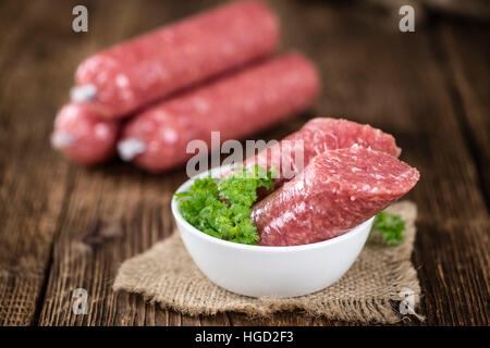 Di carne macinata di maiale salsiccia (cucina tedesca; messa a fuoco selettiva) su sfondo di legno Foto Stock