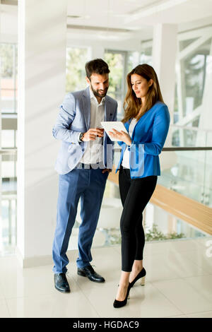 Azienda giovane con la compressa in un ufficio moderno Foto Stock