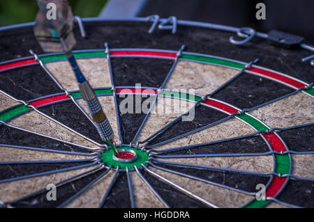 Freccia Dart di colpire nel target center di dartboard Foto Stock