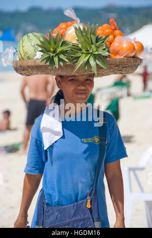 La donna porta un cesto di frutta sulla testa, Filippine Foto Stock