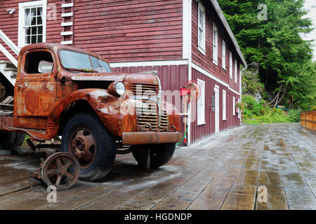 Vecchio arrugginito carrello parcheggiato su wharf Boardwalk e negozi, Telegraph Cove, Isola di Vancouver, Canada Foto Stock