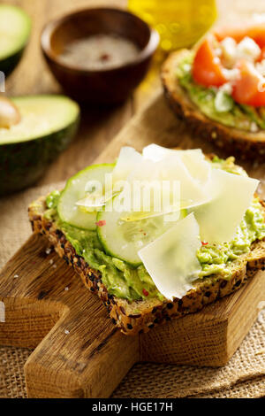 Avocado toast con il cetriolo e scaglie di parmigiano Foto Stock