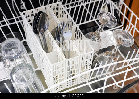 Aprire lavastoviglie con cucchiai, forchette, bicchieri e bicchieri di vino pronto per pulire Foto Stock