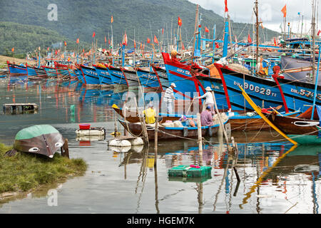 Ancorate barche da pesca della predizione del tifone che sopraggiungono, pescatori riassettavano le reti. Foto Stock