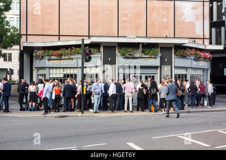 Gli impiegati nella città di Londra avente i drinks del dopo lavoro al Sea Horse pub bar, Queen Victoria Street, London, Regno Unito Foto Stock