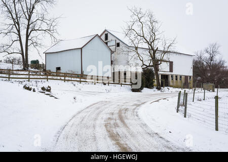 Coperta di neve su strada e fienile vicino a Jefferson, Pennsylvania. Foto Stock