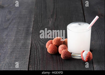 Vetro a freddo succo di lychee sul vecchio tavolo in legno Foto Stock