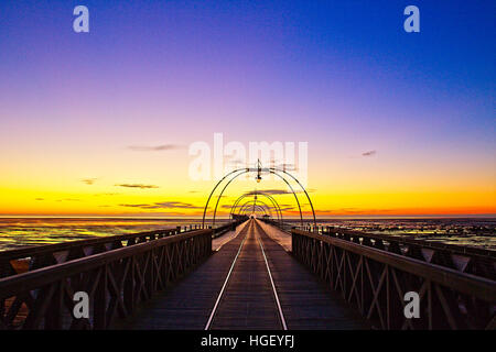 Guardando lungo Southport Pier al tramonto, Merseyside, Lancashire, Inghilterra, Regno Unito. Foto Stock