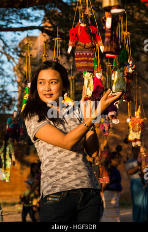 Giovane donna in posa con i tradizionali burattini al tempio Dhammayangyi,Bagan, Myanmar. Foto Stock