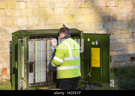 Le comunicazioni telefoniche ingegnere di lavoro sul telefono cavi scatola in Chipping Campden,Inghilterra Foto Stock