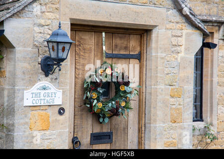 Ghirlanda di Natale sulla porta di un cottage in Lower Slaughter, Cotswolds, Inghilterra Foto Stock