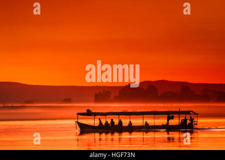 Barca con passeggeri durante il bellissimo tramonto sul fiume Tsiribihina in Madagascar Foto Stock