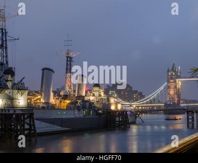 Patroni si riuniscono per un evento sul dispositivo HMS Belfast nella parte anteriore del Tower Bridge di Londra, Inghilterra Foto Stock