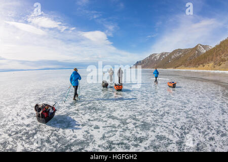 Una donna e un uomo con una mazza e trekking pole è di ghiaccio Baikal Foto Stock