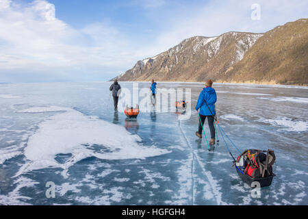 Una donna e un uomo con una mazza e trekking pole è di ghiaccio Baikal Foto Stock