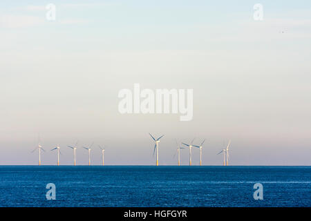 Inghilterra, Reculver. Kentish Flats per centrali eoliche nel canale inglese poco dopo l'alba. In chiara luce blu del cielo. Mare calmo. Foto Stock