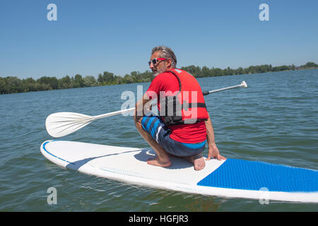 Coppia attraente rider contemplando la natura seduta sulla scheda pala Foto Stock