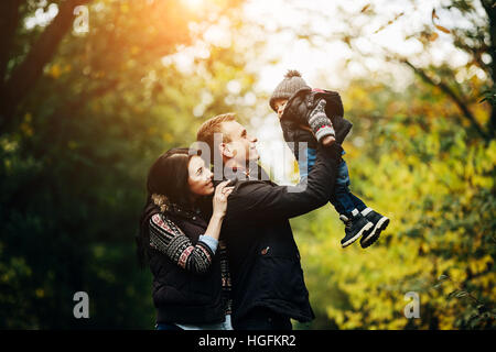 Famiglia giovane e figlio neonato in autunno park Foto Stock