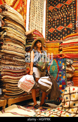 La donna nel mercato di tappeti Foto Stock