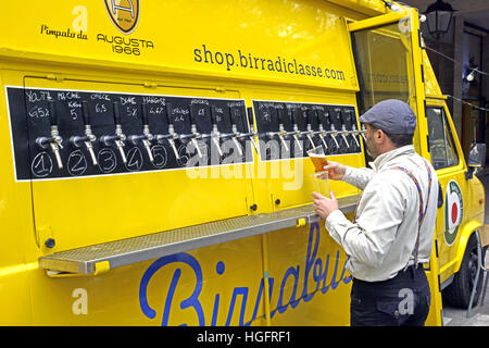 Kiev, Ucraina - 15 Maggio: barista si versa la birra nel bicchiere di plastica durante la Street Food Festival su , 2016. Birreria Staropramen è stata fondata in Praque nel 1869. La seconda più grande in Repubblica Ceca Foto Stock