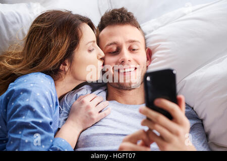 L'uomo prendendo un selfie con la donna a letto Foto Stock