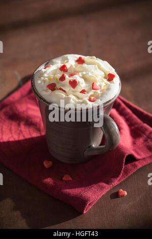 Tazza di caffè con panna e cuori rossi Foto Stock