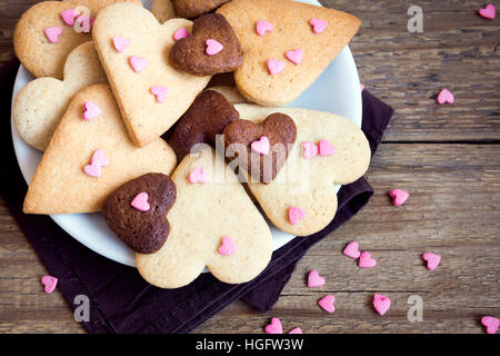 A forma di cuore i cookie su un sfondo di legno per il giorno di San Valentino - festa in casa la pasticceria buiscuits biscotti, Valentino concetto di amore Foto Stock