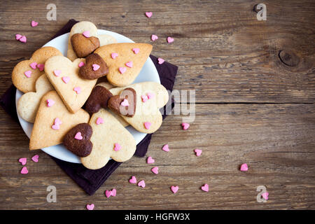 A forma di cuore i cookie su legno rustico sfondo per il giorno di San Valentino - festa in casa la pasticceria buiscuits biscotti, Valentino concetto di amore Foto Stock