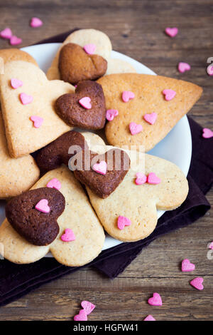 A forma di cuore i cookie su legno rustico sfondo per il giorno di San Valentino - festa in casa la pasticceria buiscuits biscotti, Valentino concetto di amore Foto Stock