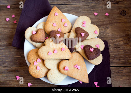 A forma di cuore i cookie su legno rustico sfondo per il giorno di San Valentino - festa in casa la pasticceria buiscuits biscotti, Valentino concetto di amore Foto Stock