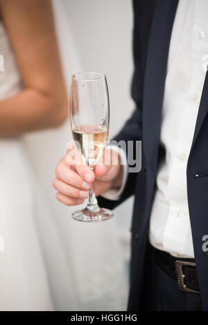 Lo sposo è con in mano un bicchiere di champagne. Giorno di nozze. Foto Stock