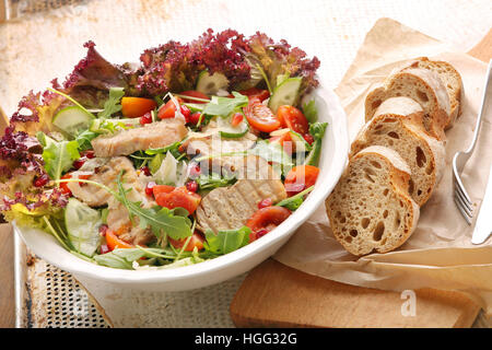 Insalata fresca con braciole di maiale alla griglia, rucola e i semi di melograno Foto Stock