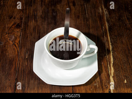 Cucchiaio in posizione eretta in una tazza di caffè forte Foto Stock