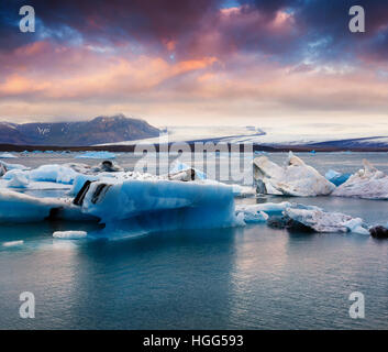 Floating di blu Iceberg di Jokulsarlon laguna glaciale. Tramonto colorato in Vatnajokull National Park, sud-est di Islanda, l'Europa. Stile artistico post Foto Stock