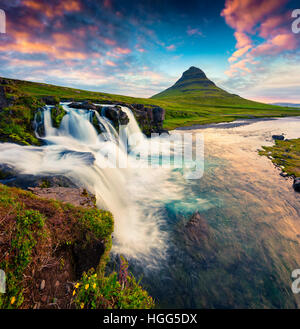 Estate tramonto sulla famosa cascata Kirkjufellsfoss e Kirkjufell mountain.Colorata scena sulla penisola Snaefellsnes,l'Islanda. Foto Stock