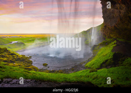 Serata colorata vista dal centro della famosa cascata Seljalandfoss. Braethtaken tramonto nel sud dell'Islanda, l'Europa. Foto Stock