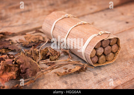 Close up di un cubano a mano scatola di sigari, con secchi di foglie di tabacco Foto Stock