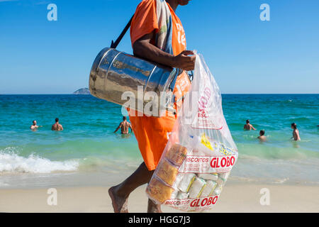 RIO DE JANEIRO - Febbraio 26, 2016: Spiaggia venditore a vendere mate, Sud America, tè e Globo marca biscotti, una specialità locale, passeggiate a Ipanema. Foto Stock