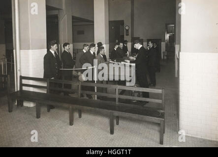 Gli immigrati in attesa in linea per la lavorazione con l'immigrazione i funzionari dell'Ufficio di presidenza. - Ellis Island stazione di immigrazione 1902-1913 Foto Stock