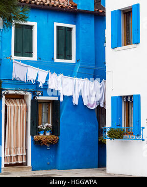 Blue House con lavaggio bianco appeso al di fuori di esso sull'isola di Burano Venezia Italia Foto Stock