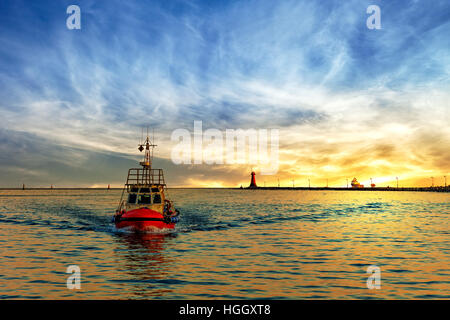 Barca pilota di ritorno al porto di sunrise. Foto Stock