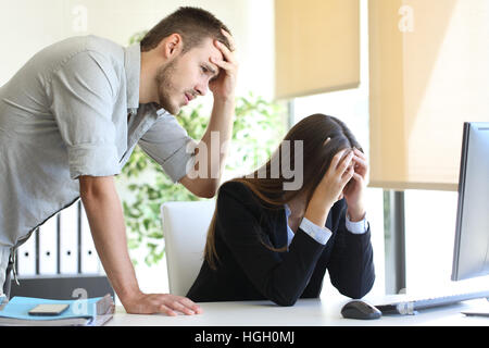 Due preoccupato i colleghi con un computer desktop che piange dopo un grande errore in ufficio Foto Stock