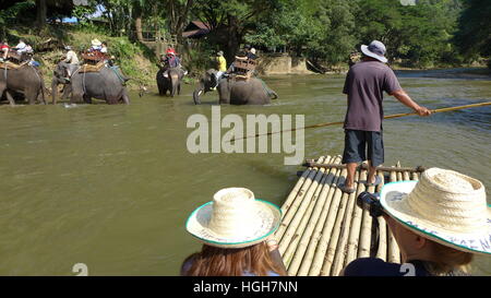 Guida tailandese di prendere i turisti su una zattera di bamboo lungo il fiume. Chiang Mai, Thailandia Foto Stock