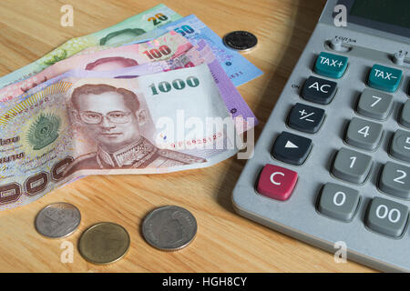 Thai di banconote e monete con la calcolatrice Foto Stock