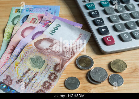 Thai di banconote e monete con la calcolatrice Foto Stock