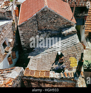 Un quadro storico dal 1976 che mostra due donne anziane disponendo i fichi secchi sulla parte superiore di un tetto nella città di Gelsa, sull'isola di Hvar in Croazia Foto Stock