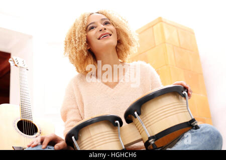 Crea la tua musica. Battendo il ritmo dei tamburi. Bongo, percussione. Ragazza che gioca i tamburi di bongo, tamburi piccoli. Foto Stock